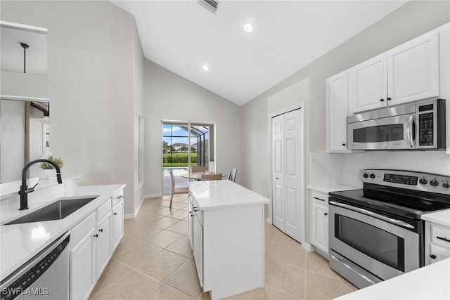 kitchen featuring a kitchen island, appliances with stainless steel finishes, white cabinetry, light tile patterned flooring, and sink