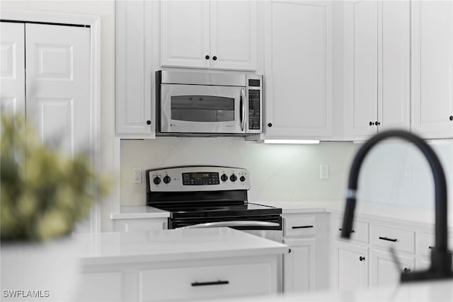 kitchen with appliances with stainless steel finishes and white cabinets