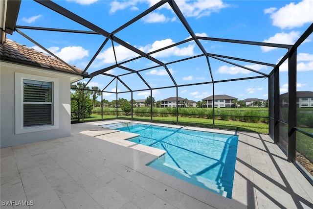 view of swimming pool with a lawn, a patio, and glass enclosure