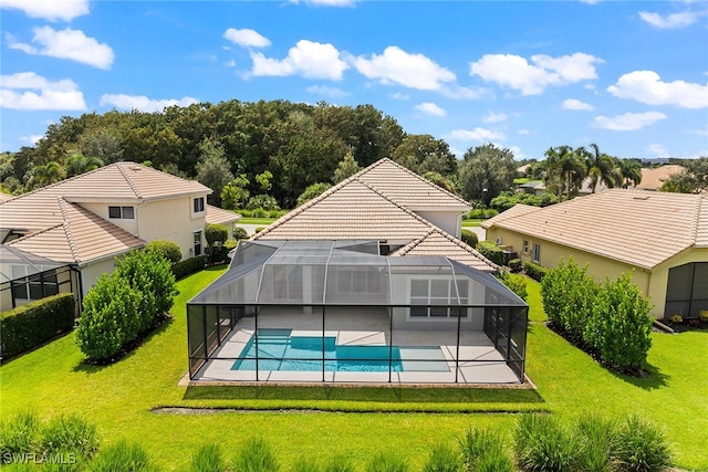 rear view of property featuring a patio area, glass enclosure, and a lawn