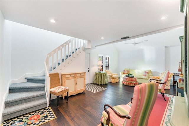 living room featuring dark wood-type flooring and ceiling fan