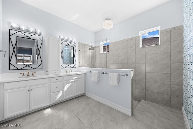 bathroom featuring tiled shower, vanity, and tile patterned flooring