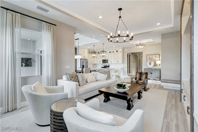 living room featuring a tray ceiling and an inviting chandelier