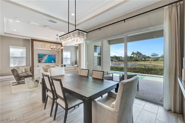 dining space featuring a raised ceiling, plenty of natural light, and a notable chandelier