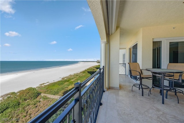 balcony featuring a water view and a beach view