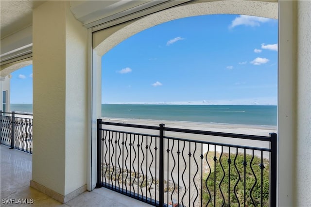 balcony featuring a water view and a beach view