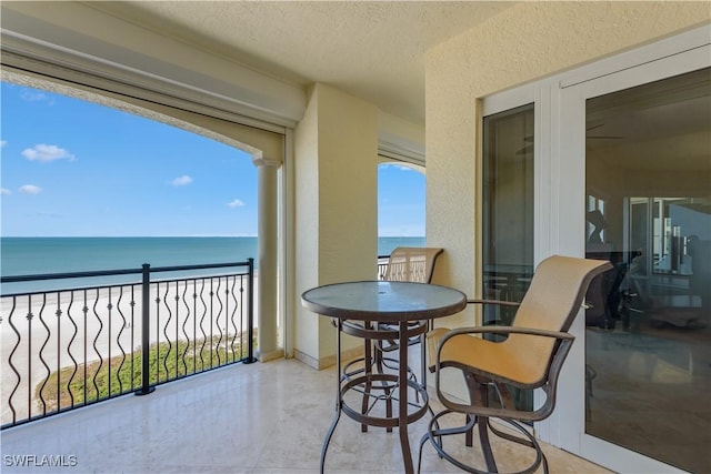 balcony with a water view and a beach view