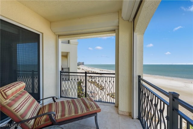 balcony featuring a water view and a beach view