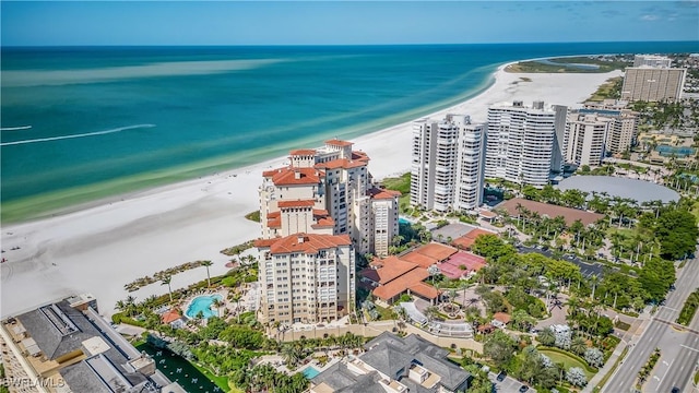 birds eye view of property with a water view and a beach view