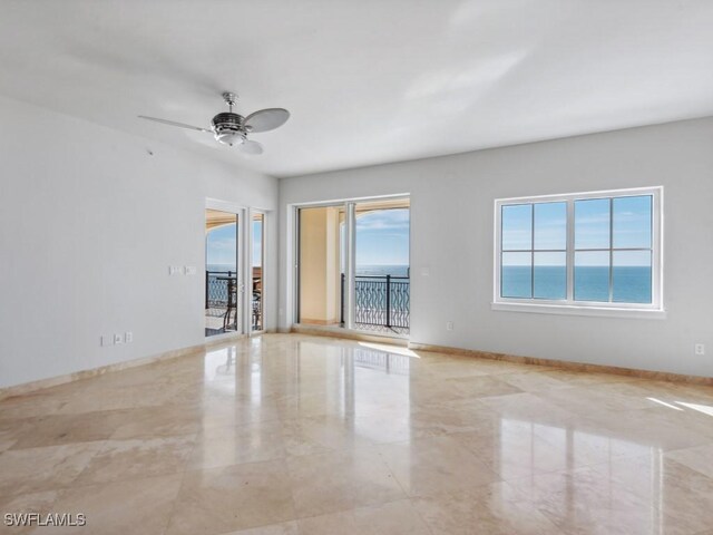 unfurnished room featuring a water view and ceiling fan