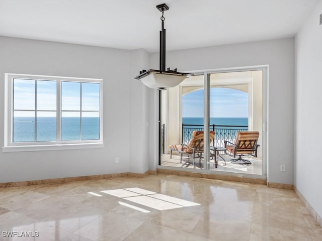 unfurnished dining area featuring a water view