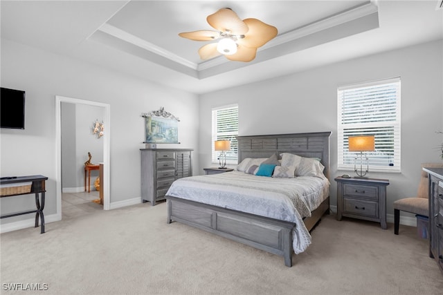 carpeted bedroom featuring multiple windows, a tray ceiling, crown molding, and ceiling fan