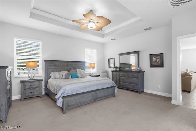 carpeted bedroom with a tray ceiling and ceiling fan