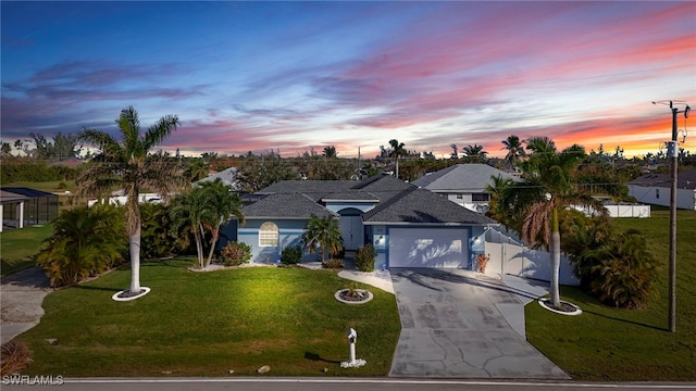 view of front of property featuring a garage and a lawn