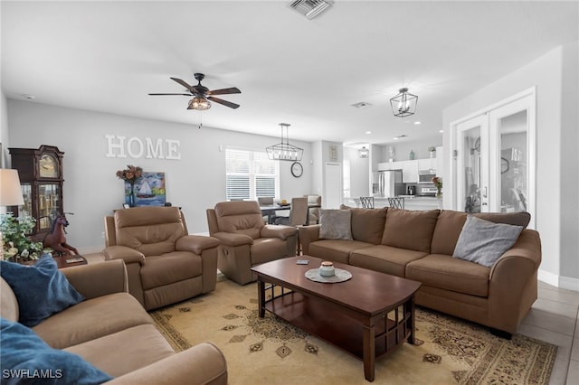 living room featuring ceiling fan with notable chandelier and light tile patterned floors