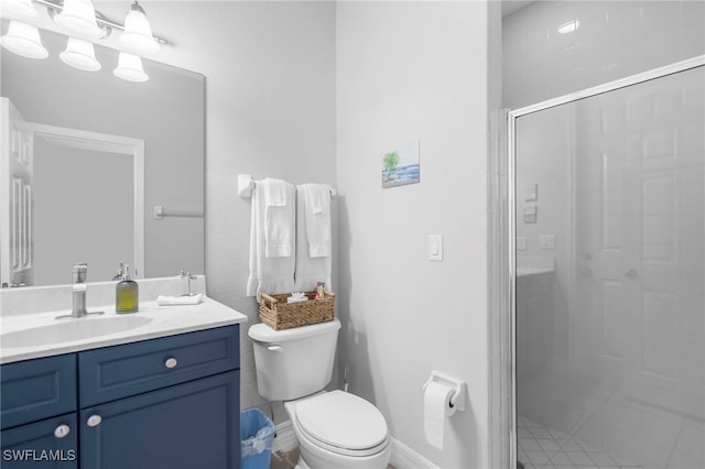 bathroom featuring vanity, toilet, and a shower with shower door