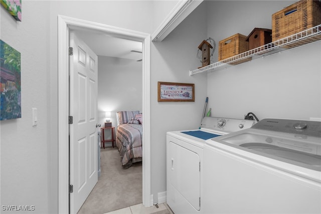 laundry area with washing machine and clothes dryer and light colored carpet