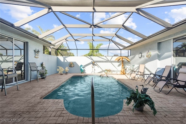 view of pool with a patio area and glass enclosure