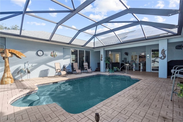 view of pool with a patio area and a lanai