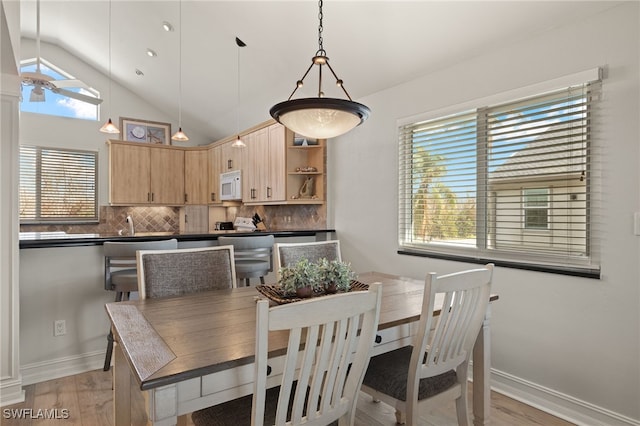 dining space with lofted ceiling and light wood-type flooring