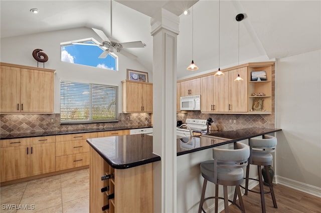 kitchen with a breakfast bar area, kitchen peninsula, decorative light fixtures, white appliances, and tasteful backsplash