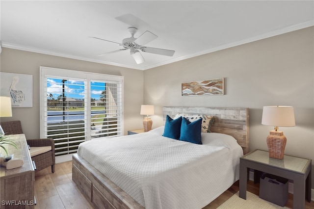 bedroom with crown molding, light hardwood / wood-style flooring, and ceiling fan