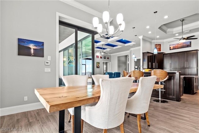 dining area featuring ornamental molding, ceiling fan with notable chandelier, and light hardwood / wood-style flooring