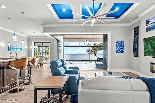 living room with sink, ceiling fan, coffered ceiling, ornamental molding, and light wood-type flooring