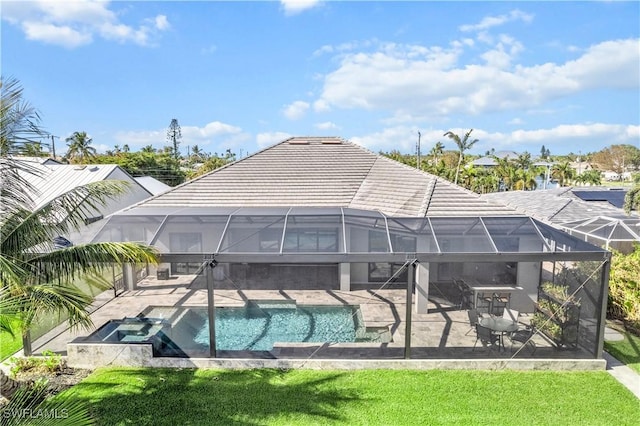 back of property featuring a patio, a pool with hot tub, glass enclosure, and a lawn