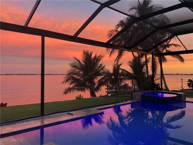 pool at dusk featuring a water view, an in ground hot tub, and glass enclosure