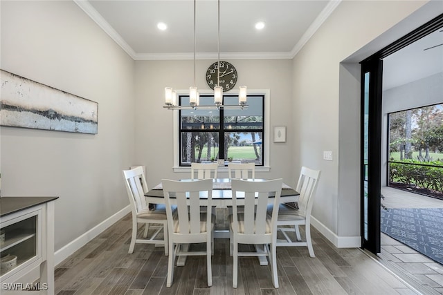 dining area with hardwood / wood-style floors, a chandelier, and ornamental molding