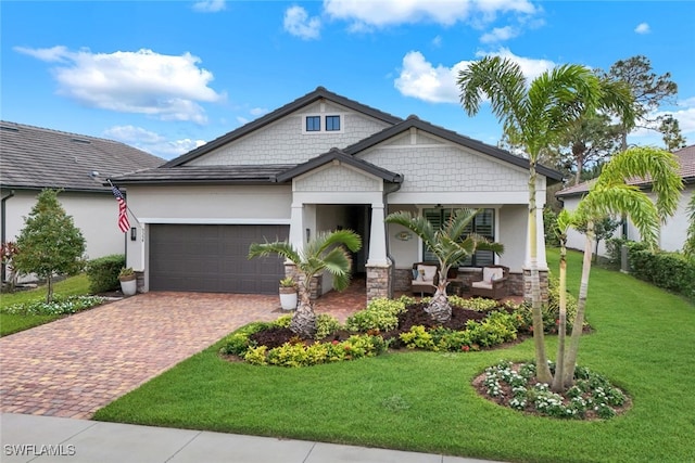 craftsman inspired home featuring covered porch, a garage, and a front lawn