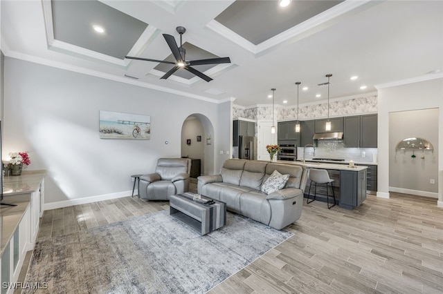 living room with coffered ceiling, light hardwood / wood-style floors, ceiling fan, and crown molding