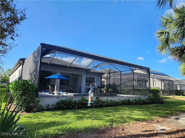 back of house featuring a patio, a lanai, and a yard