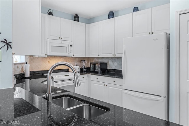 kitchen with white appliances, white cabinets, dark stone countertops, and sink