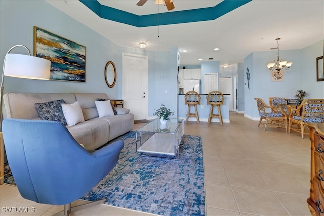 living room with light tile patterned flooring and ceiling fan with notable chandelier