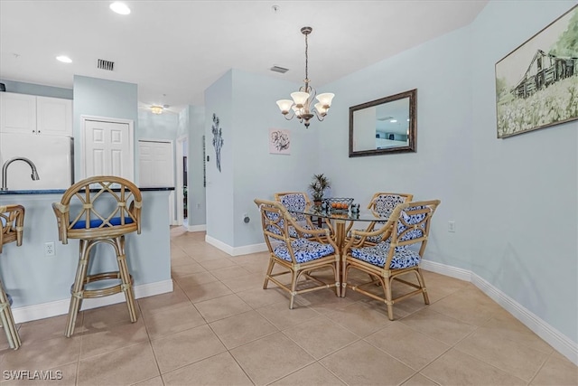 tiled dining room with a notable chandelier