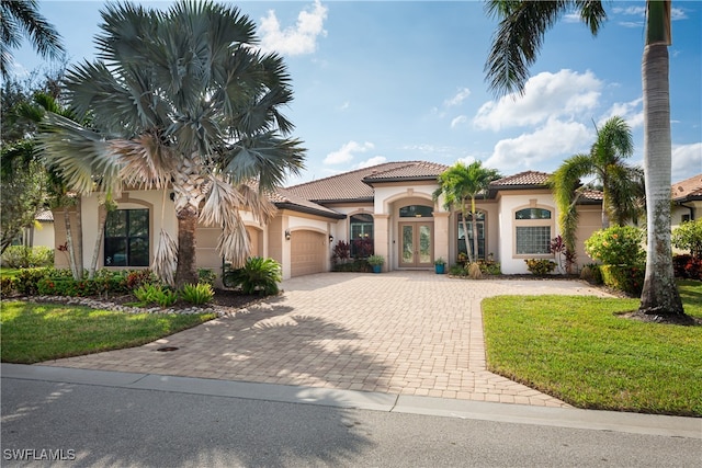 mediterranean / spanish-style home featuring a garage and a front lawn