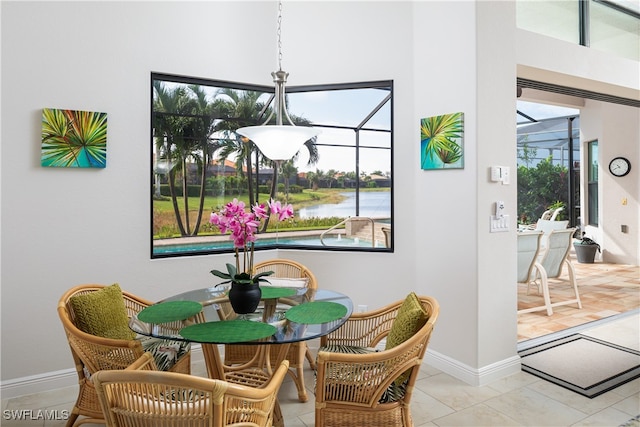 dining space with a wealth of natural light, a water view, and light tile patterned floors