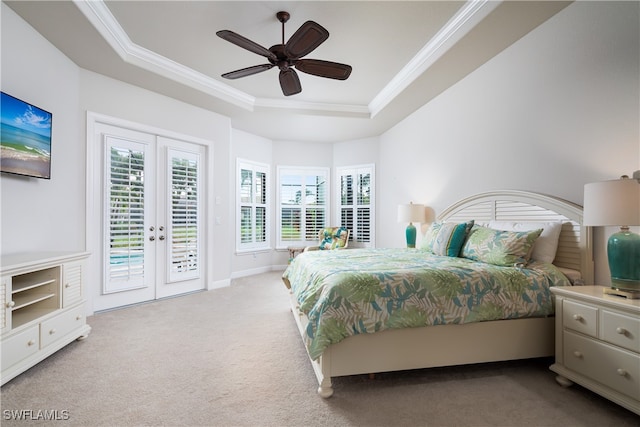 carpeted bedroom with access to exterior, french doors, ceiling fan, and a raised ceiling