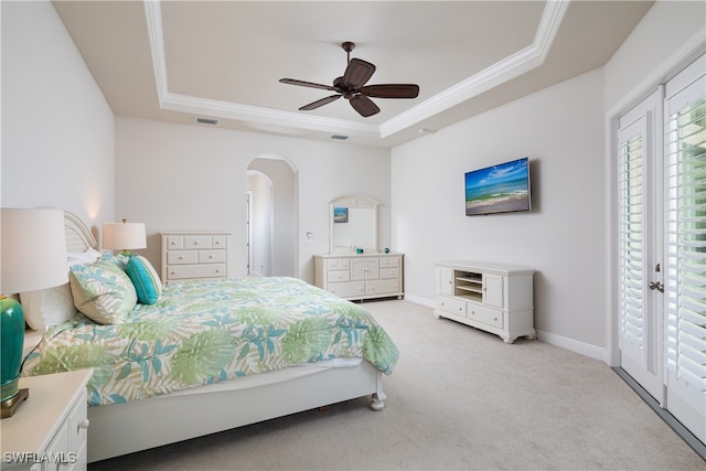 bedroom featuring access to exterior, light carpet, ceiling fan, and a raised ceiling