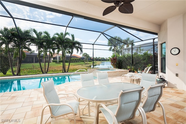 view of pool with ceiling fan, glass enclosure, a water view, and an in ground hot tub