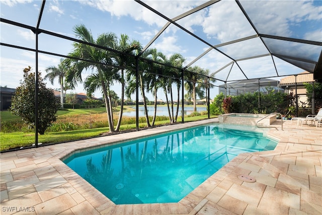 view of pool with glass enclosure, a patio area, and a water view