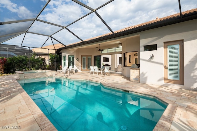 view of swimming pool with ceiling fan, a patio, a lanai, and an in ground hot tub