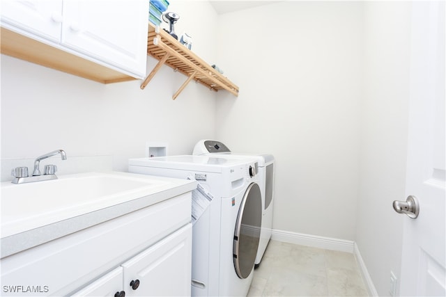 clothes washing area featuring cabinets, light tile patterned floors, sink, and washer and clothes dryer