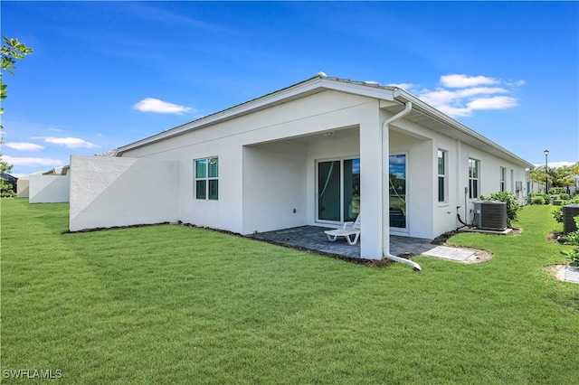 back of property with a yard, a patio, and central AC