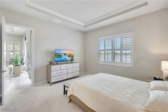 bedroom with a tray ceiling, multiple windows, and light colored carpet