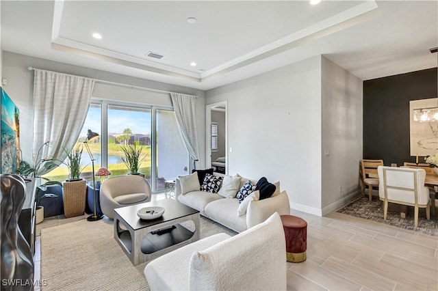 living room with light hardwood / wood-style flooring and a raised ceiling