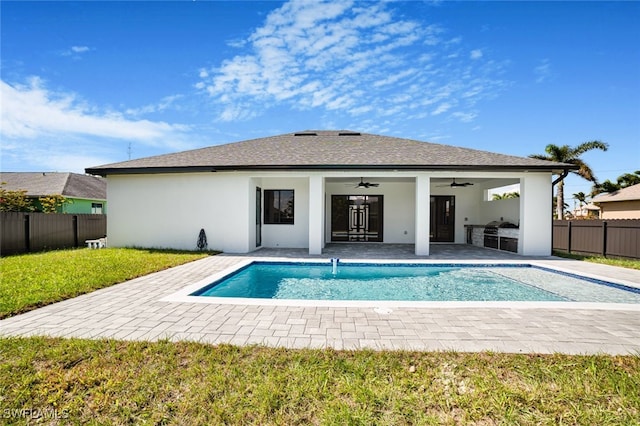 view of pool featuring an outdoor kitchen, ceiling fan, a yard, and a patio