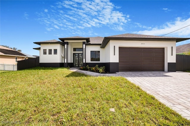 prairie-style home with a garage and a front lawn